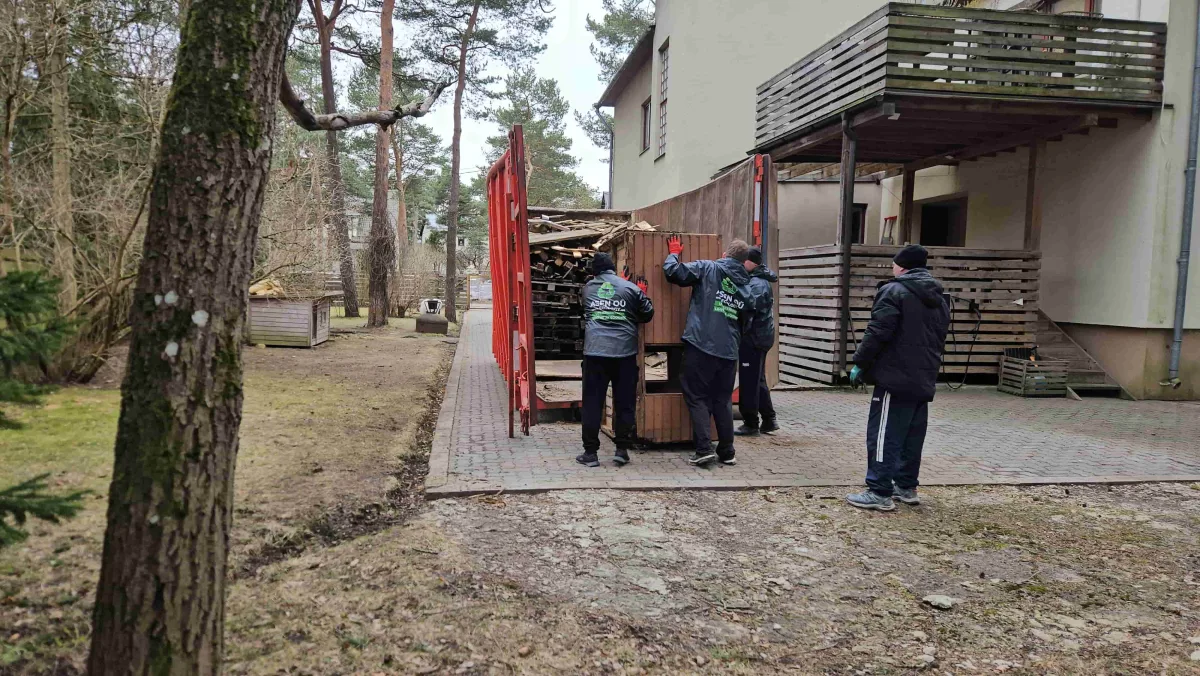 Бригада грузчиков у красного контейнера возле дома
