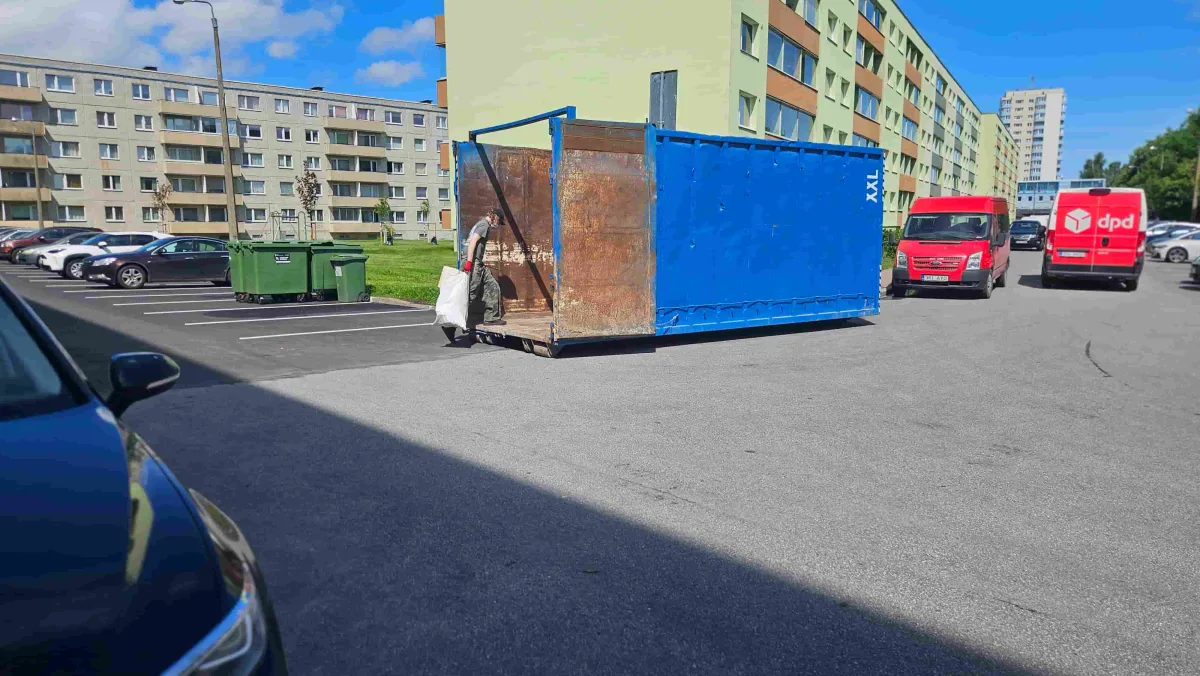 Синий контейнер на парковке у многоквартирных домов