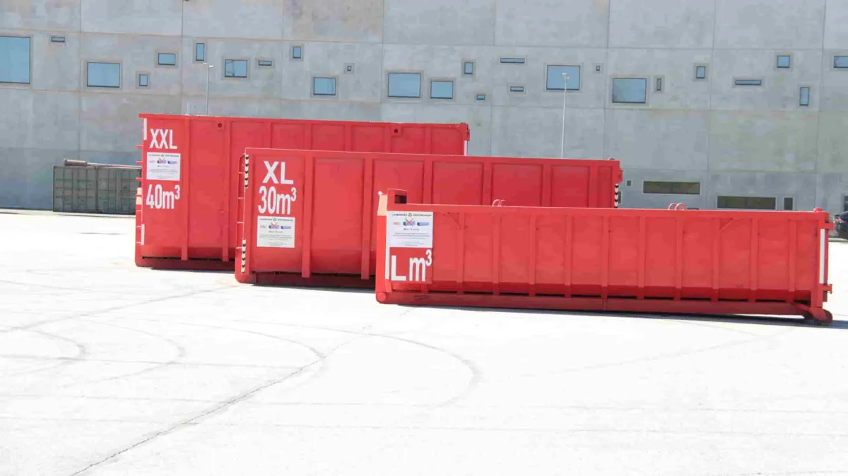Пустые контейнеры XXL, XL и L на асфальтовой площадке