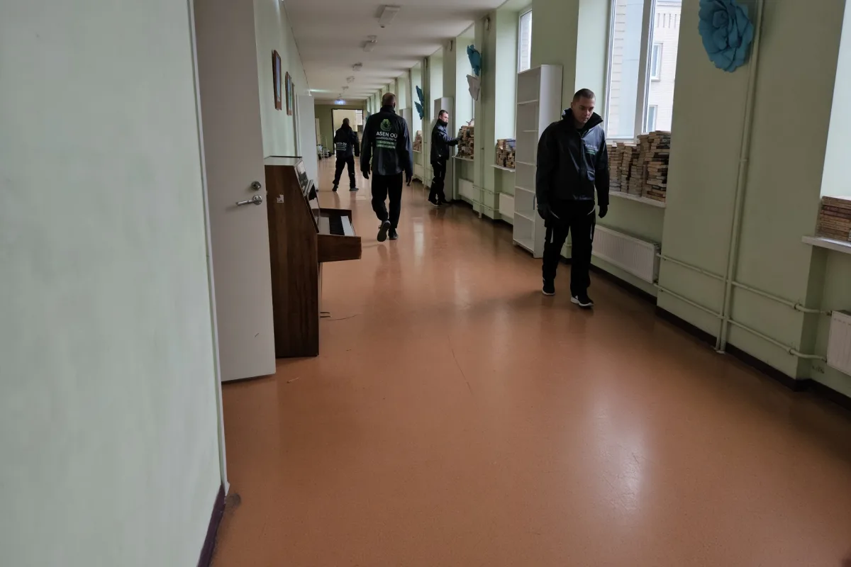 Рабочие осматривают длинный коридор освобождаемого здания