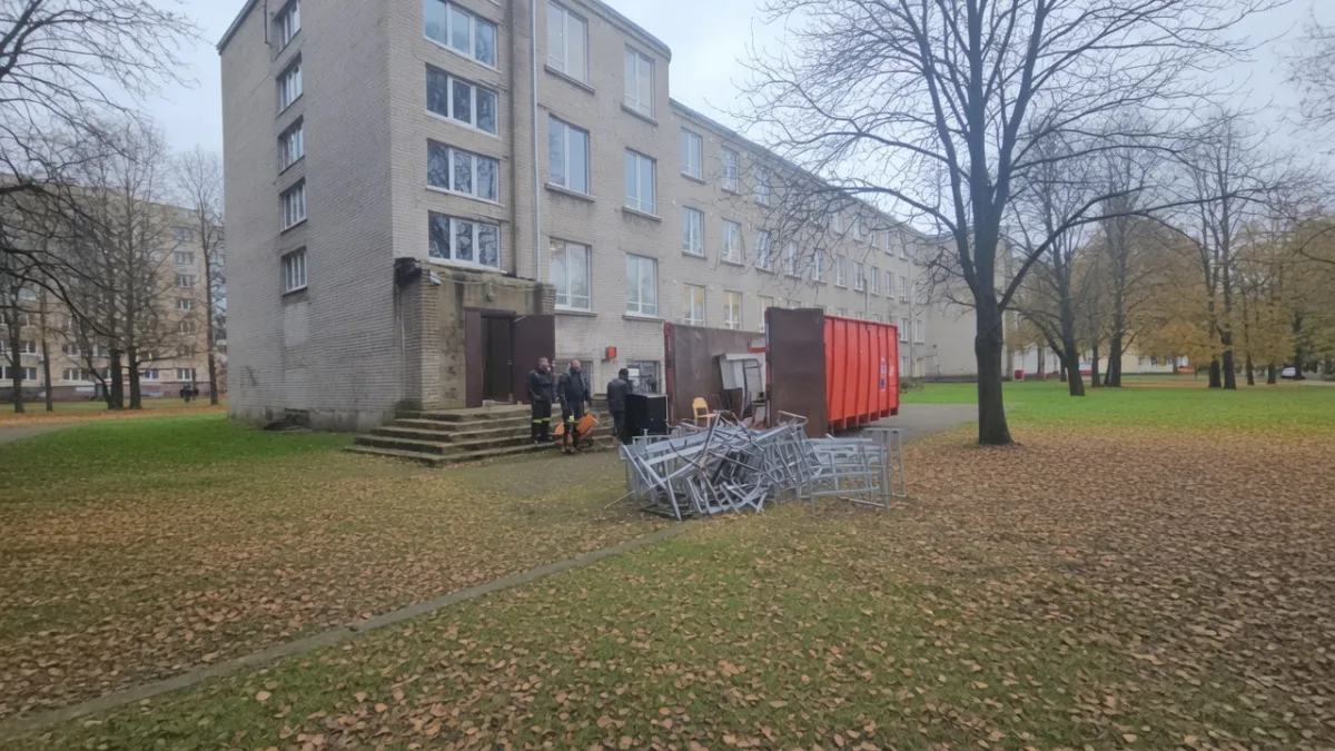 Многоэтажный дом, контейнер и вынесенные вещи на газоне