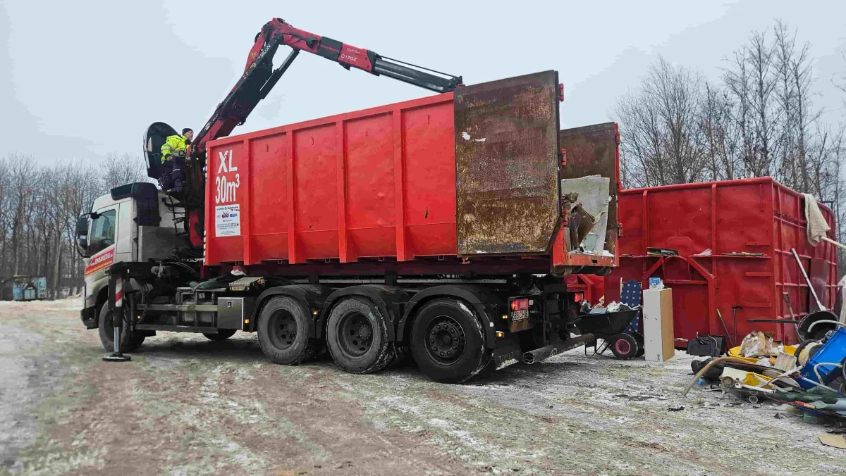 Грузовик с краном-манипулятором и красным контейнером зимой