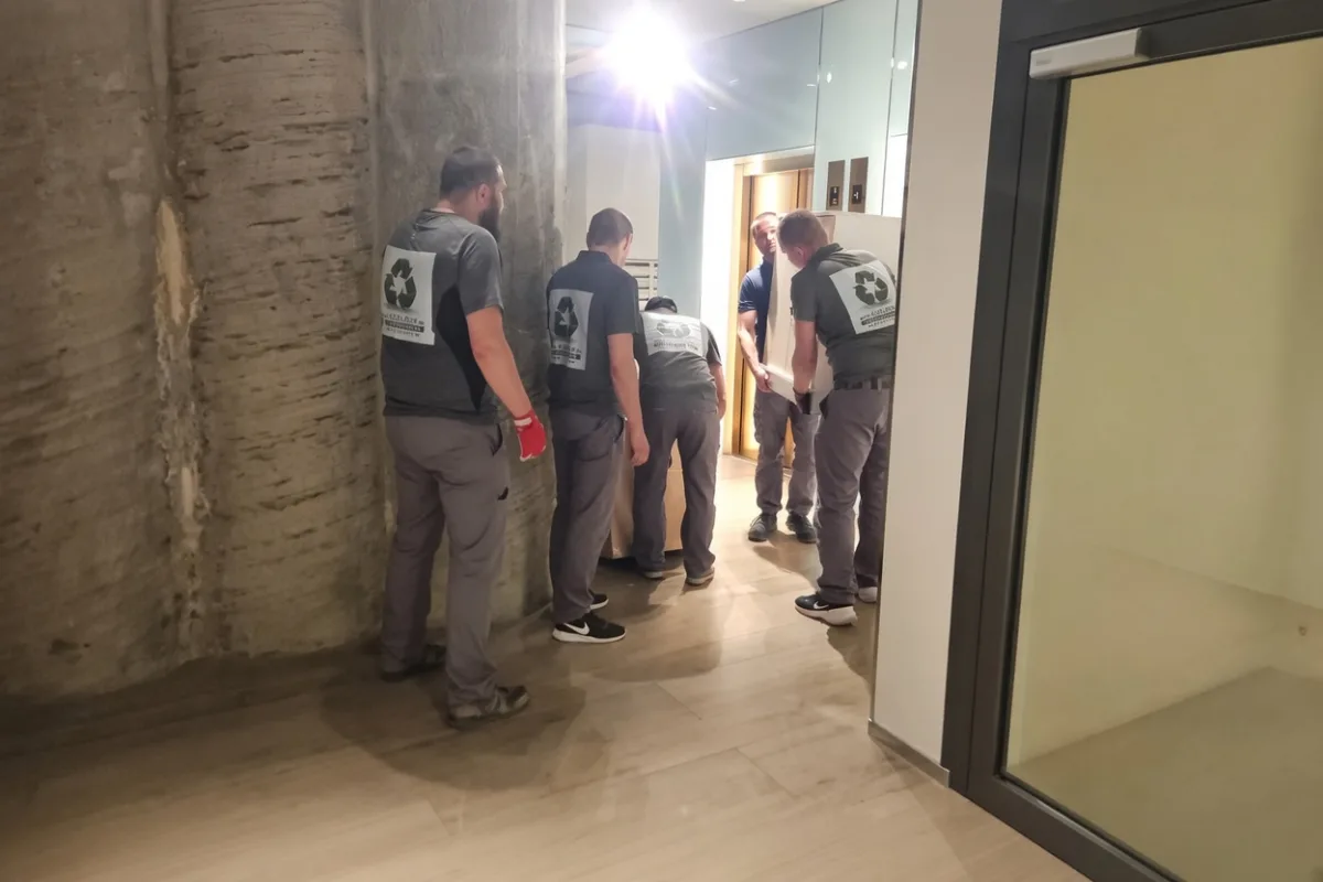 Бригада грузчиков в коридоре дома перед выносом вещей