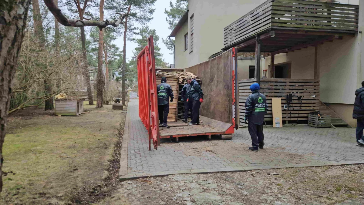 Открытый красный контейнер на подъездной дорожке у дома