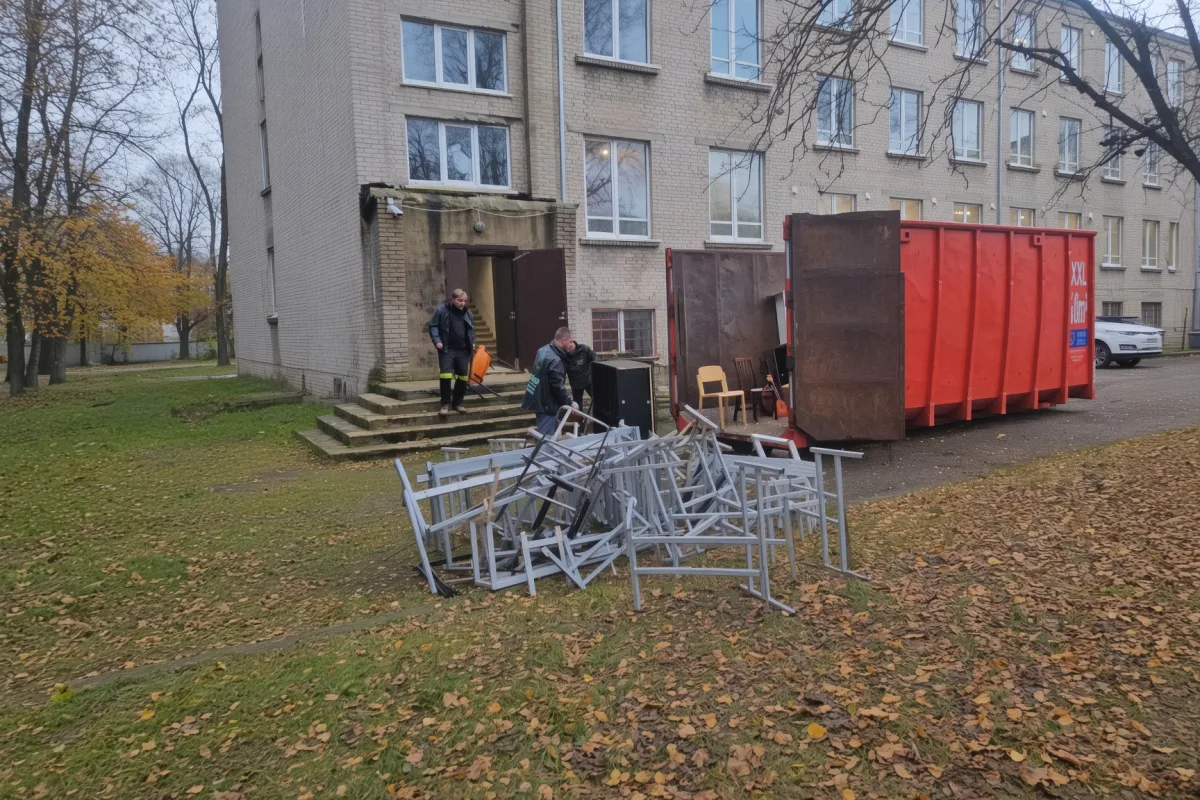 Вынос мебели из дома к красному контейнеру осенью